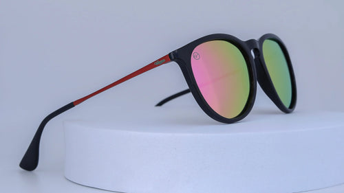 Sunglasses with pink and green gradient lenses on a white background